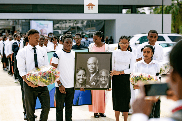 Procession carrying floral tributes and a framed family portrait