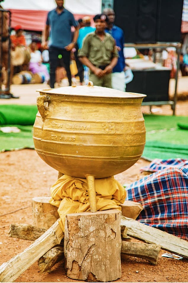 Gold ceremonial cooking pot on wooden logs