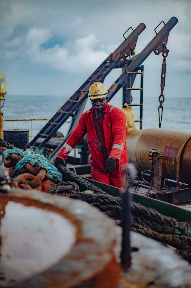 Offshore worker beside mooring chains and ropes