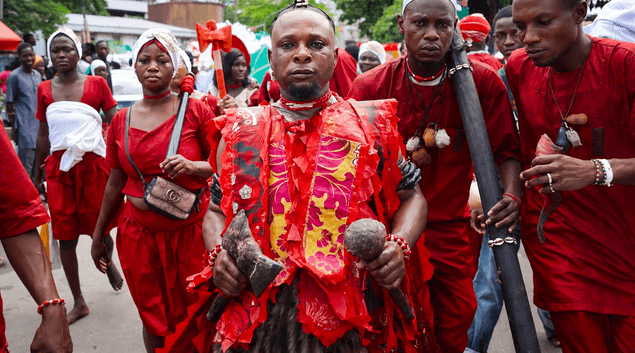 Red ceremonial procession with traditional implements