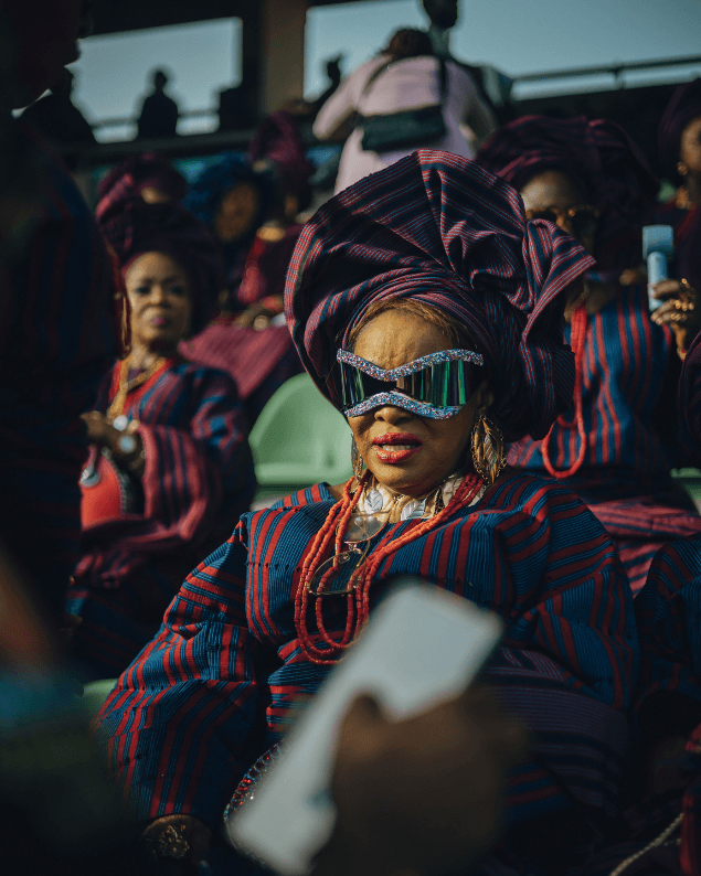 Woman in aso oke with glitter visor sunglasses