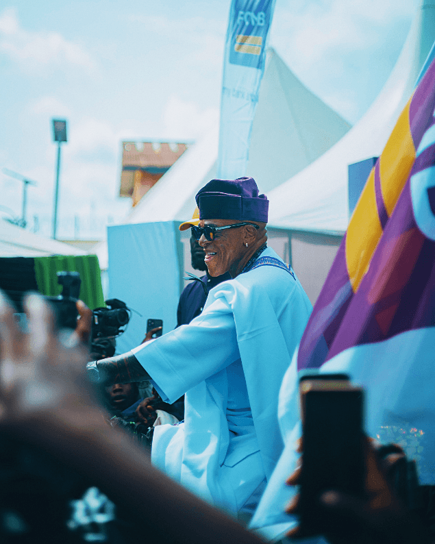 Man in light blue agbada and purple fila amid the crowd