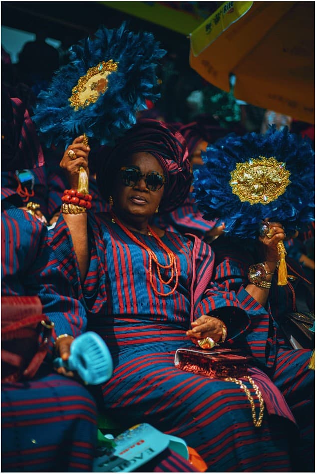 Woman holding a blue feather ceremonial fan
