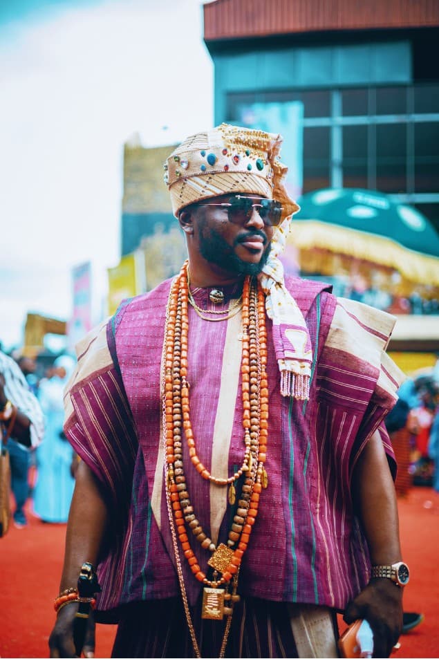 Man in purple striped agbada with coral beads and irukere