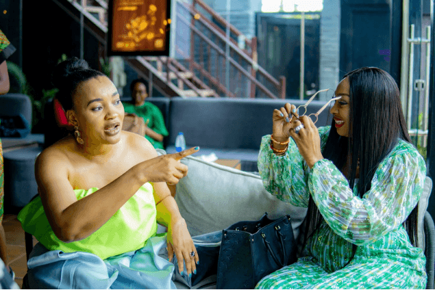 Two women sharing a lively moment on the couch