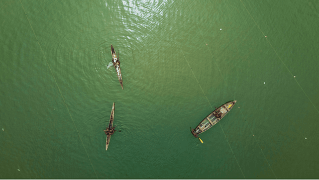 Overhead shot of three wooden boats among fishing floats